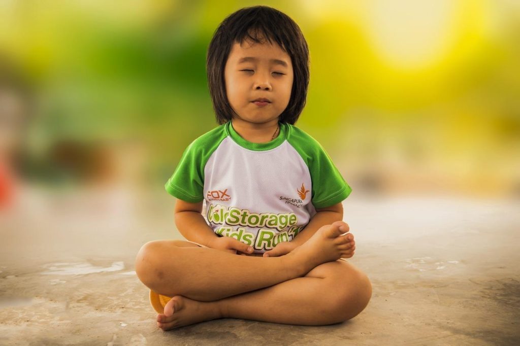 A Little Girl Sitting On Concrete Floor as She Practices Mindfulness